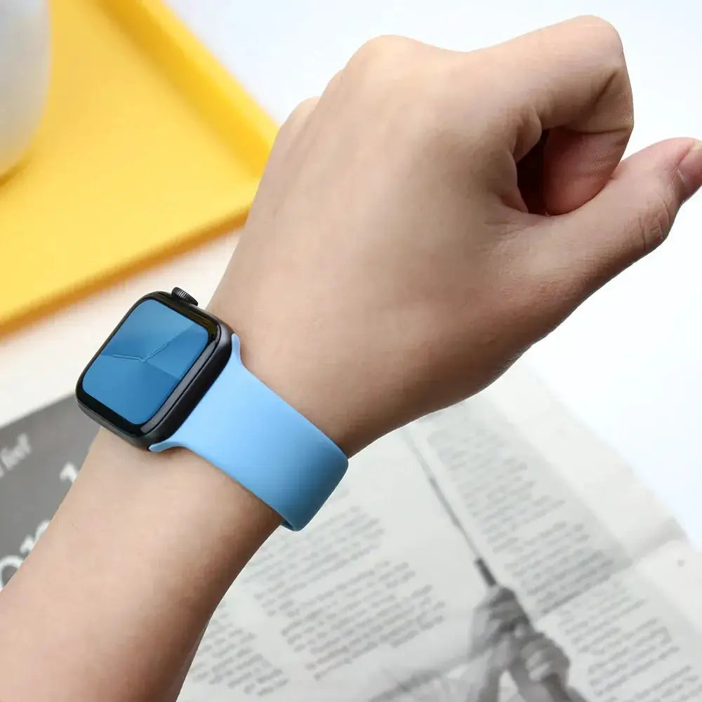 Silicone Apple Watch band in blue shown on wrist; compatible with 38–45mm Apple Watch sizes