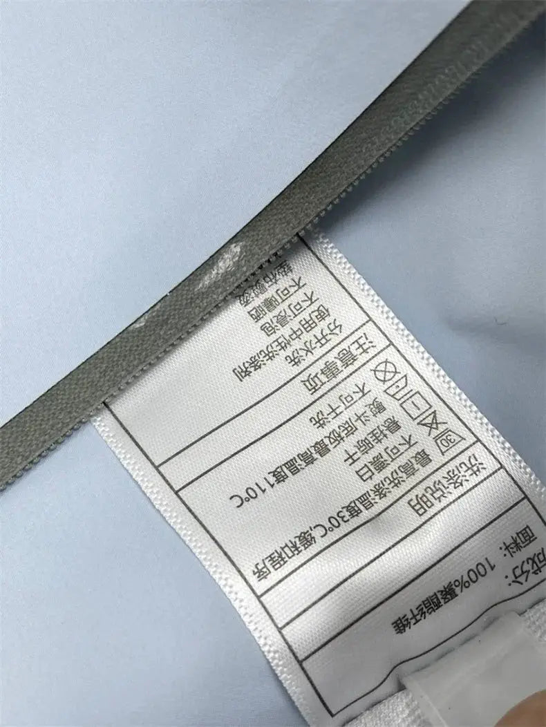 Men's windproof soft-shell outdoors jacket; light blue fabric with care label visible.
