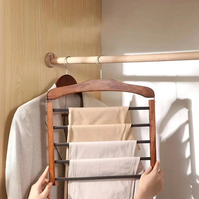 Solid wood multi-tier trouser rack with dark metal bars mounted in a closet.