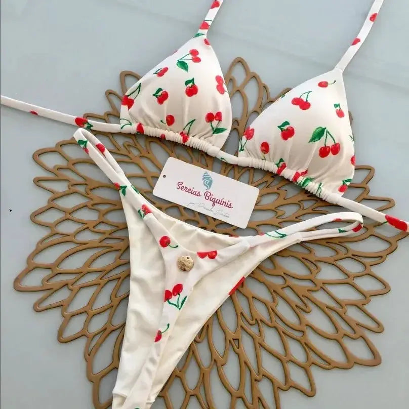 Bikini set with white cherry-print halter top and thong bottoms, adjustable straps.
