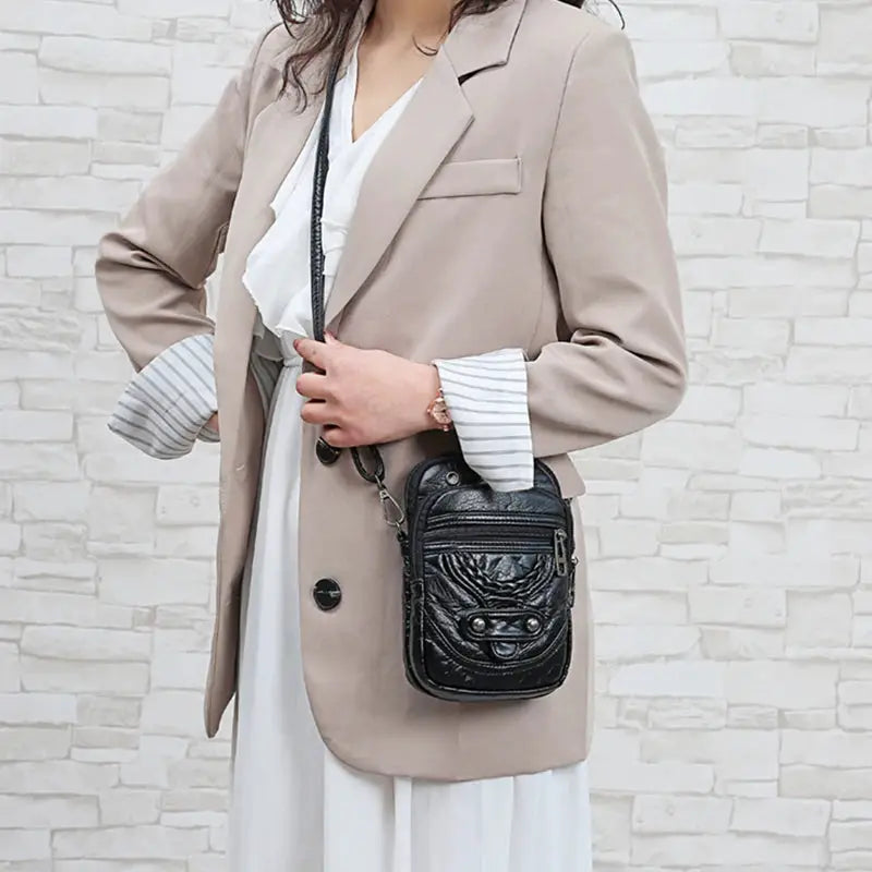 Women's messenger bag by Simples Market in black PU leather; compact crossbody with front zip pocket
