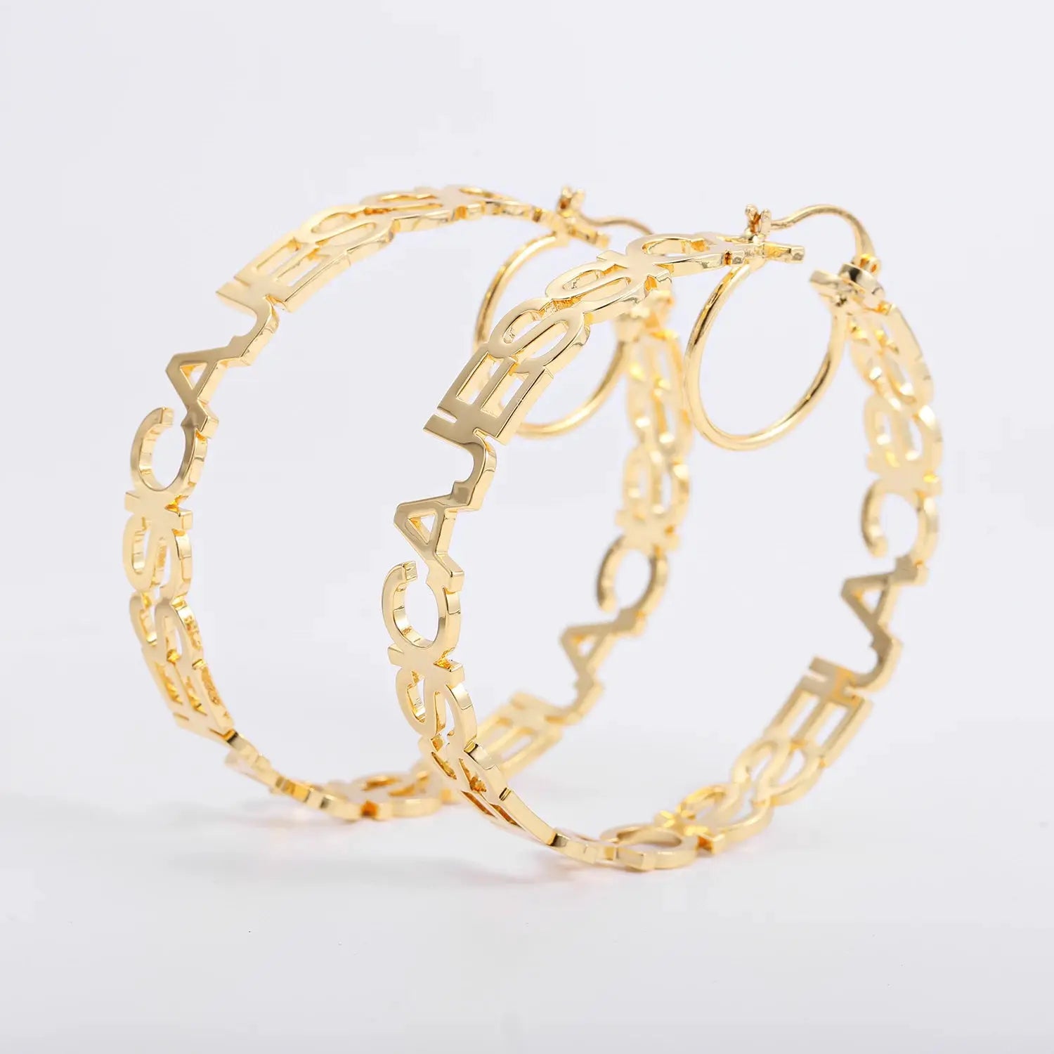 Three gold-tone stainless steel custom name hoop earrings with large circular letter designs