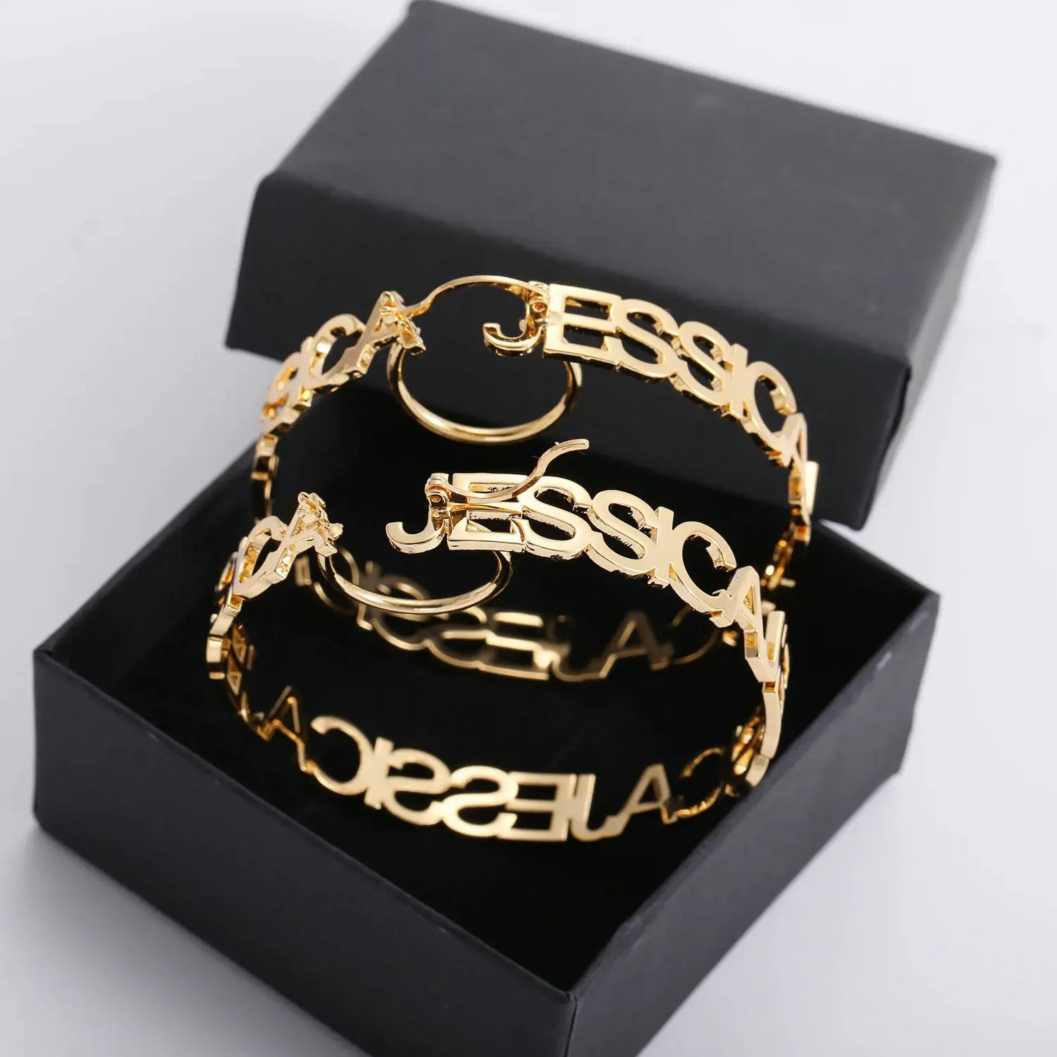 Gold-tone custom name hoop earrings, pair with large circular letter design in stainless steel