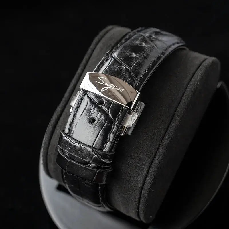 Sugess men's wristwatch with black leather strap and polished deployant clasp.