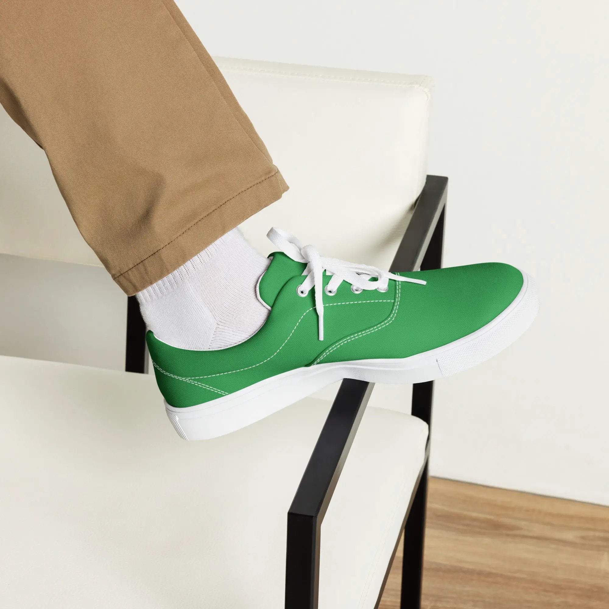 Men's green lace-up canvas shoes with white laces and white soles, worn with white socks and beige pants