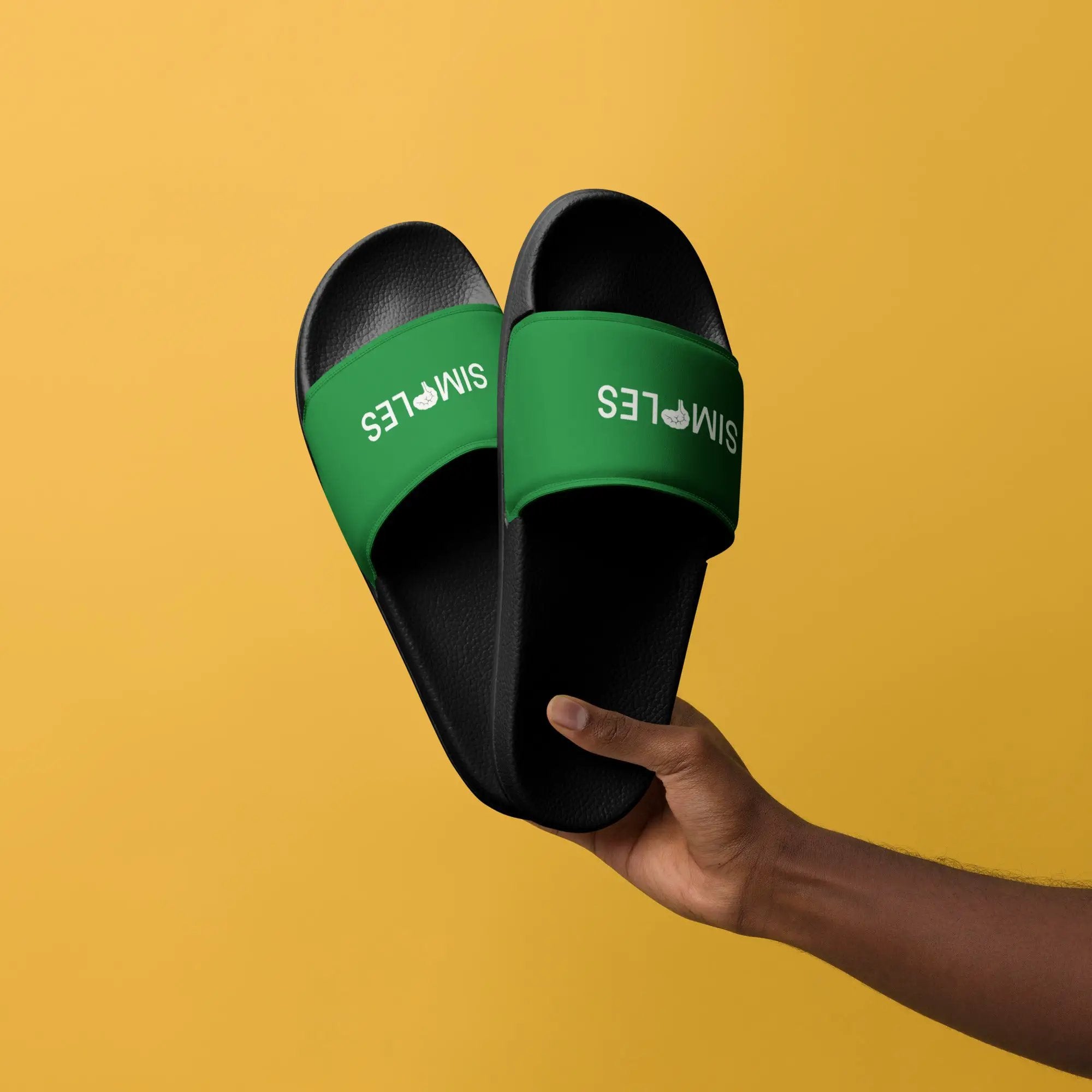 Men’s Slides by Simples Market; black textured soles with green straps bearing Simples branding (two slides)