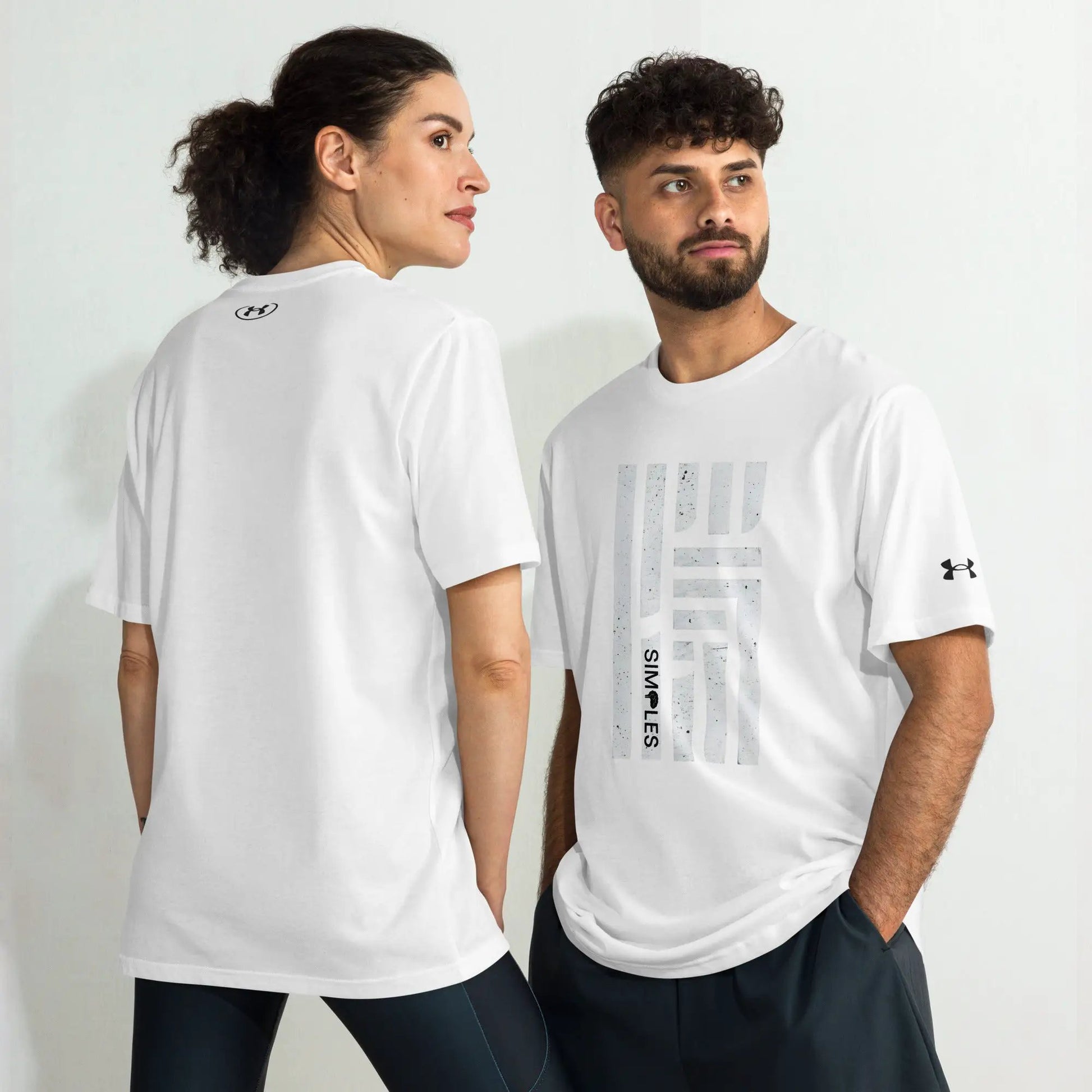 Under Armour athletic t-shirt on two models; white tees with visible UA logos on back and sleeve.