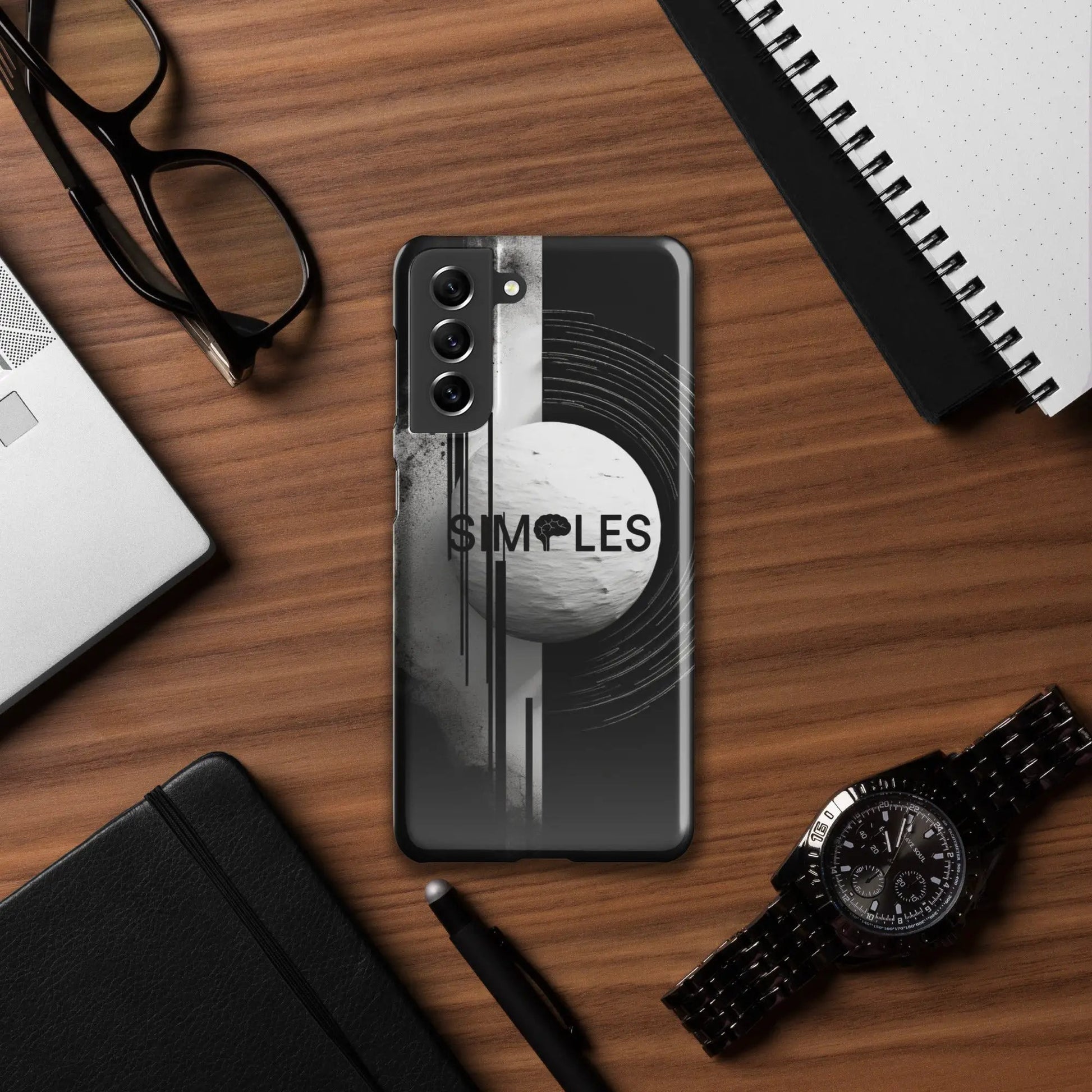Snap case for Samsung smartphone by Simples Market, black with abstract white swirl graphic on a wooden desk.