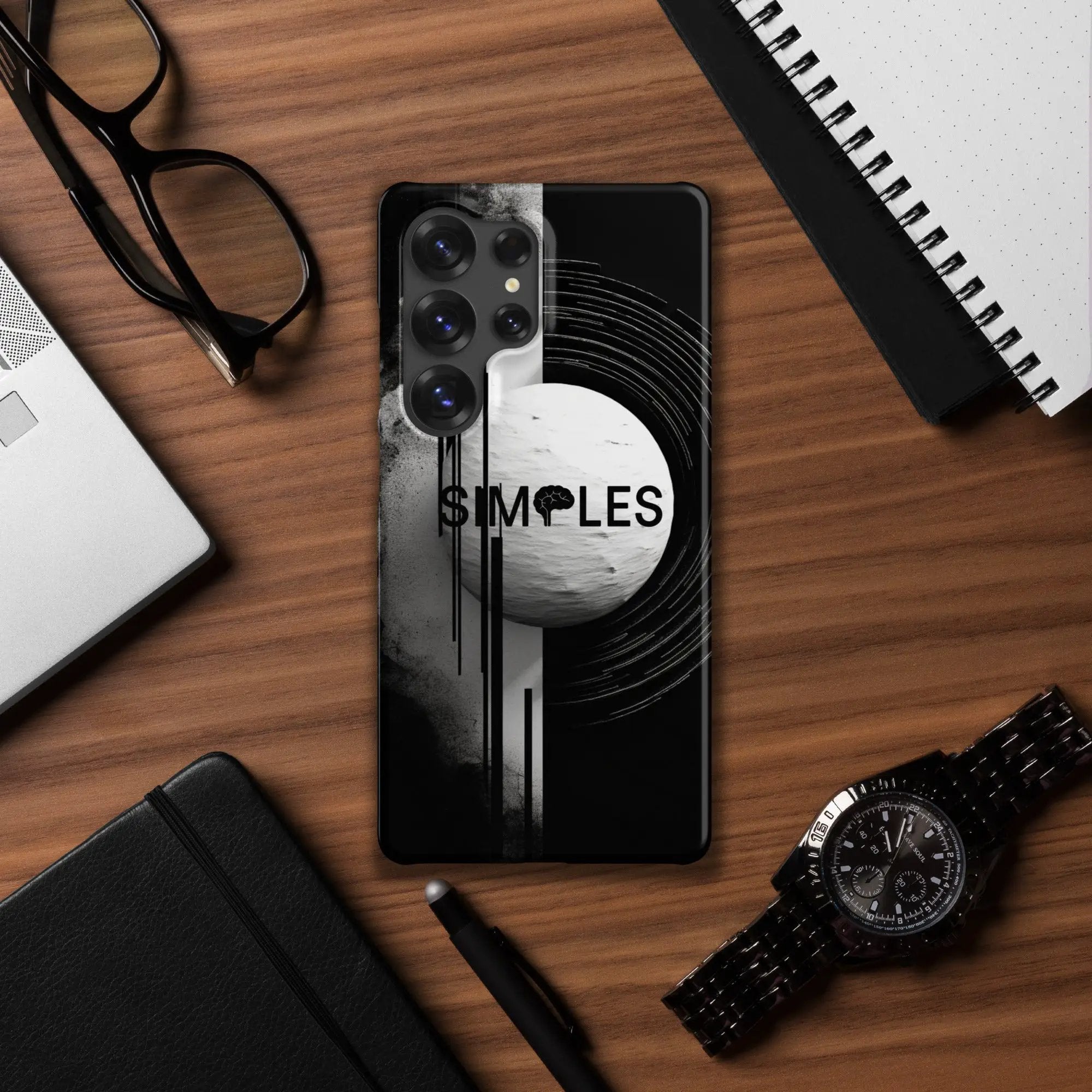 Snap case for Samsung by Simples Market; black phone case with a white circular graphic on a wooden desk